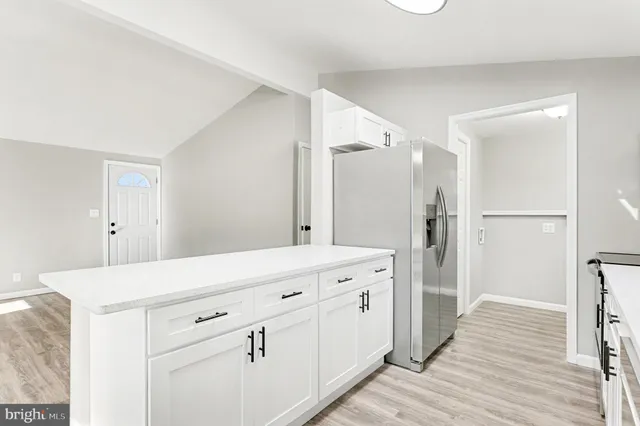 a kitchen with white cabinets and white appliances