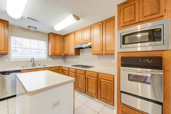 a kitchen with stainless steel appliances granite countertop a sink a stove and cabinets