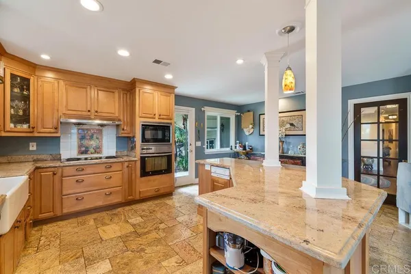 a large kitchen with kitchen island a stove a sink a dining table and chairs
