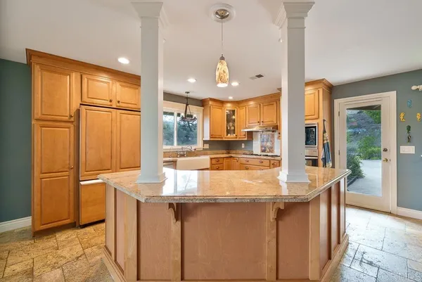 a kitchen with stainless steel appliances granite countertop a refrigerator a sink and a wooden cabinets