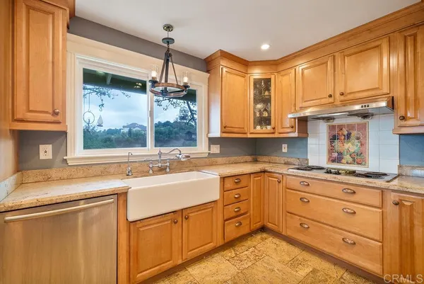 a kitchen with granite countertop a sink stainless steel appliances and cabinets