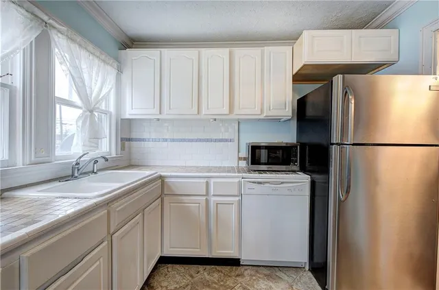a kitchen with a refrigerator sink and cabinets