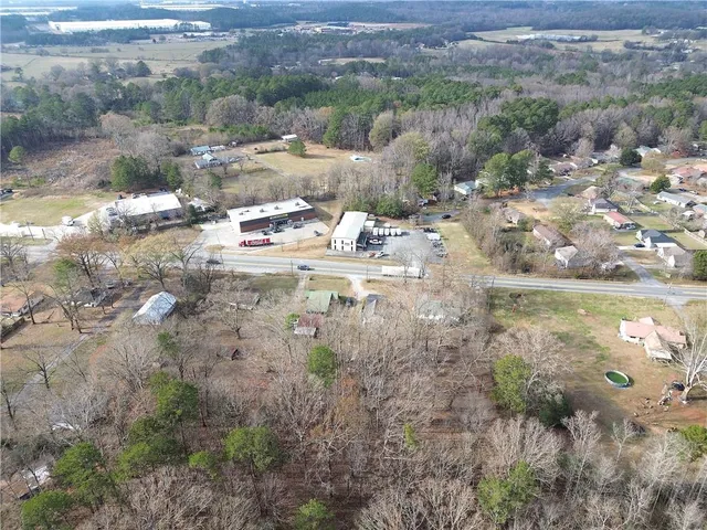 a front view of a house with a yard covered with snow and trees