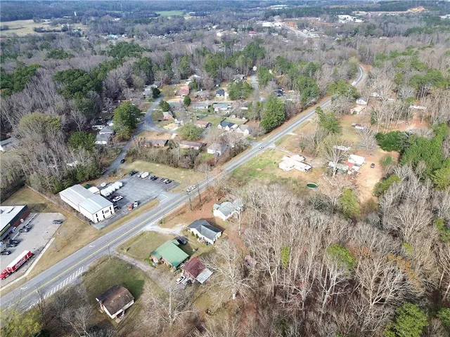 a view of a house with a yard and large tree