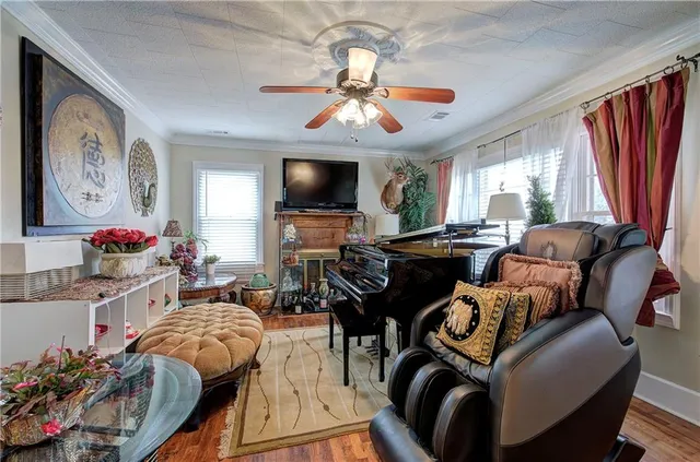 a living room with furniture a flat screen tv and a large window