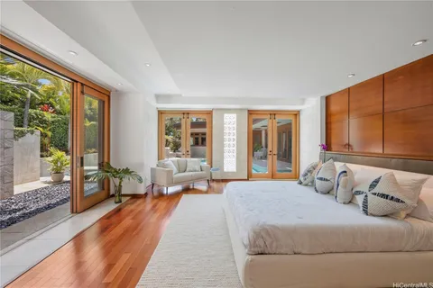 a bedroom with a large bed and large windows with outer view
