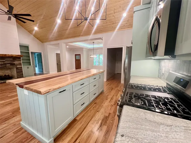 a kitchen with stainless steel appliances granite countertop a stove a sink and a refrigerator