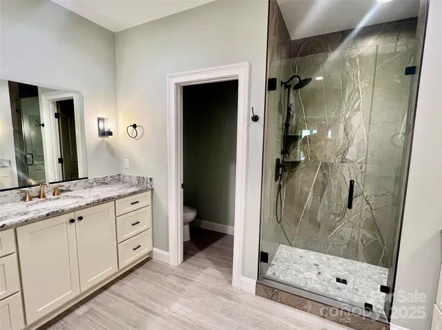 a bathroom with a granite countertop sink a mirror and a shower