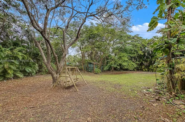 an aerial view of a house with yard and trees