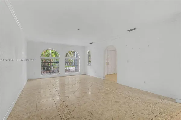 a large white kitchen with kitchen island a sink stainless steel appliances and cabinets