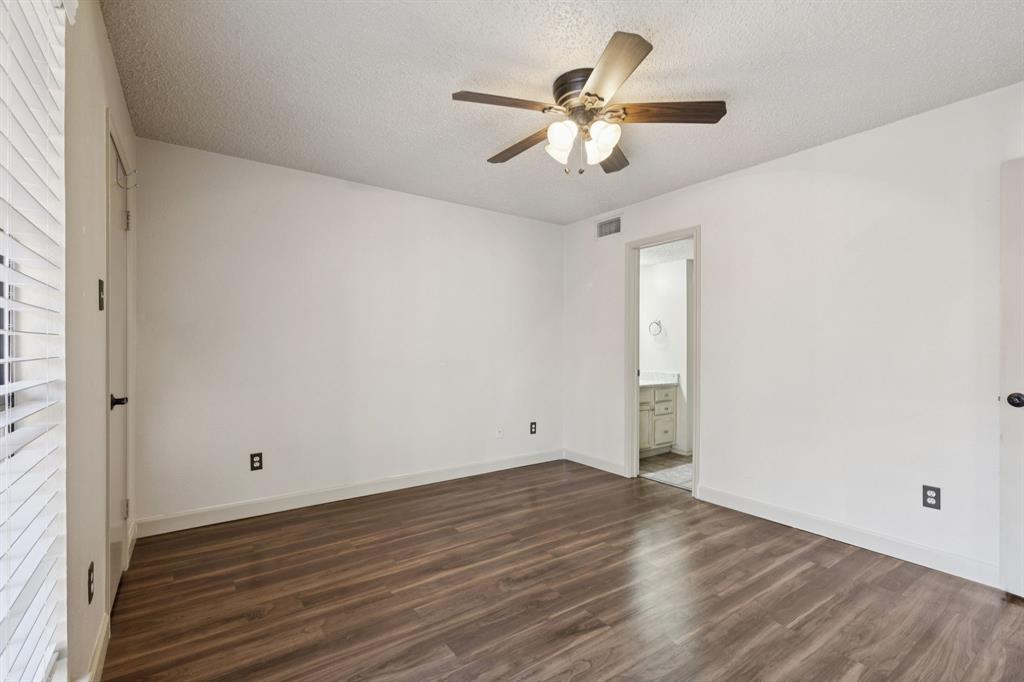 449 Harris Street, Unit 103B Coppell, TX 75019 - Photo 16 of 26 an empty room with wooden floor chandelier fan and closet area