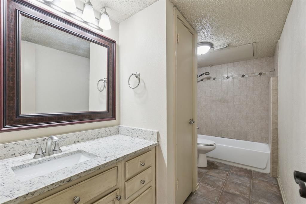 449 Harris Street, Unit 103B Coppell, TX 75019 - Photo 17 of 26 a bathroom with a granite countertop sink toilet and shower