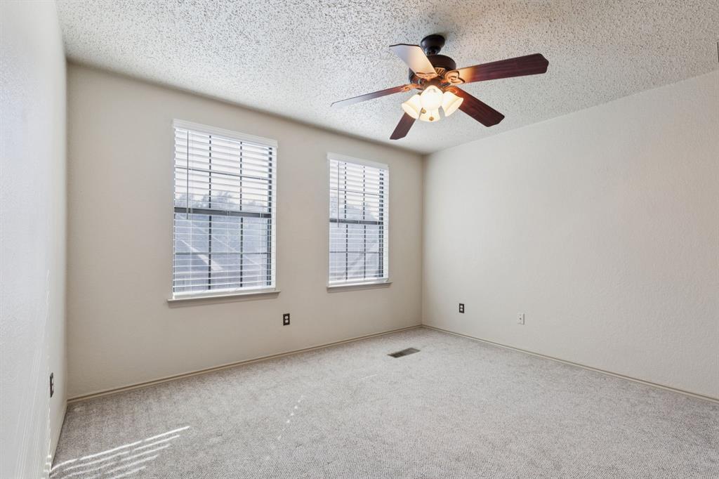 449 Harris Street, Unit 103B Coppell, TX 75019 - Photo 19 of 26 an empty room with chandelier fan and windows