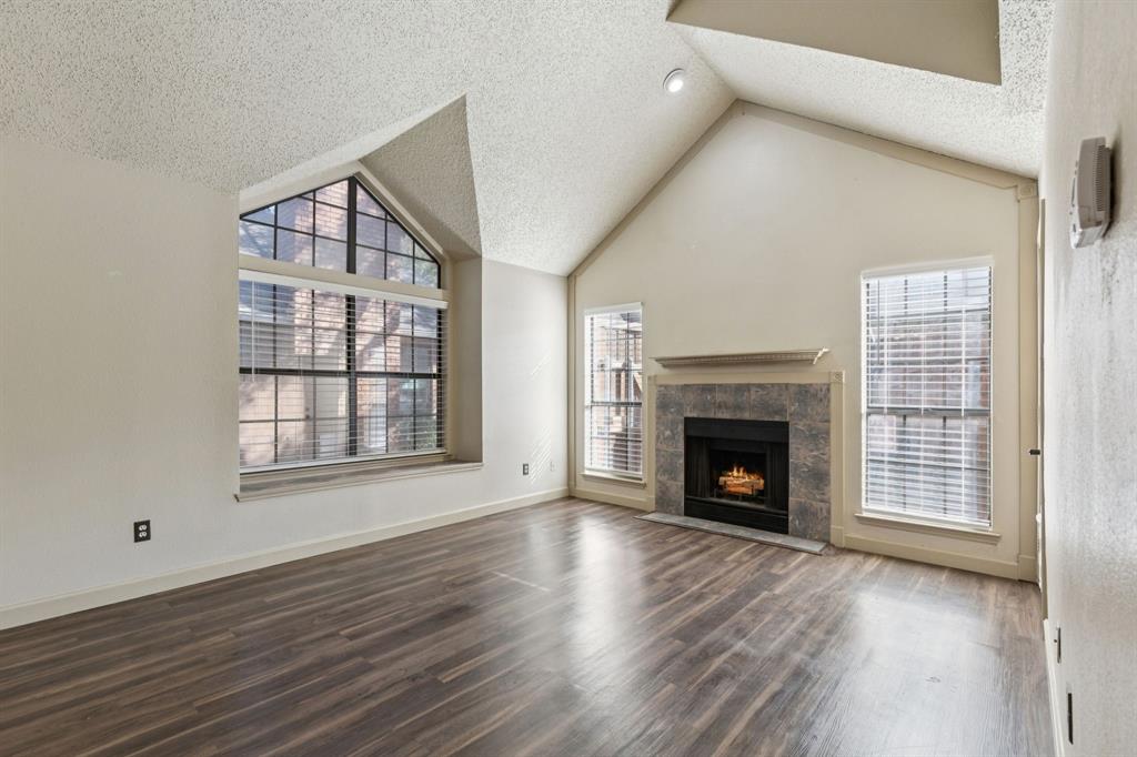 449 Harris Street, Unit 103B Coppell, TX 75019 - Photo 6 of 26 an empty room with wooden floor fireplace and windows