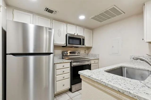 a kitchen with a stove refrigerator and microwave