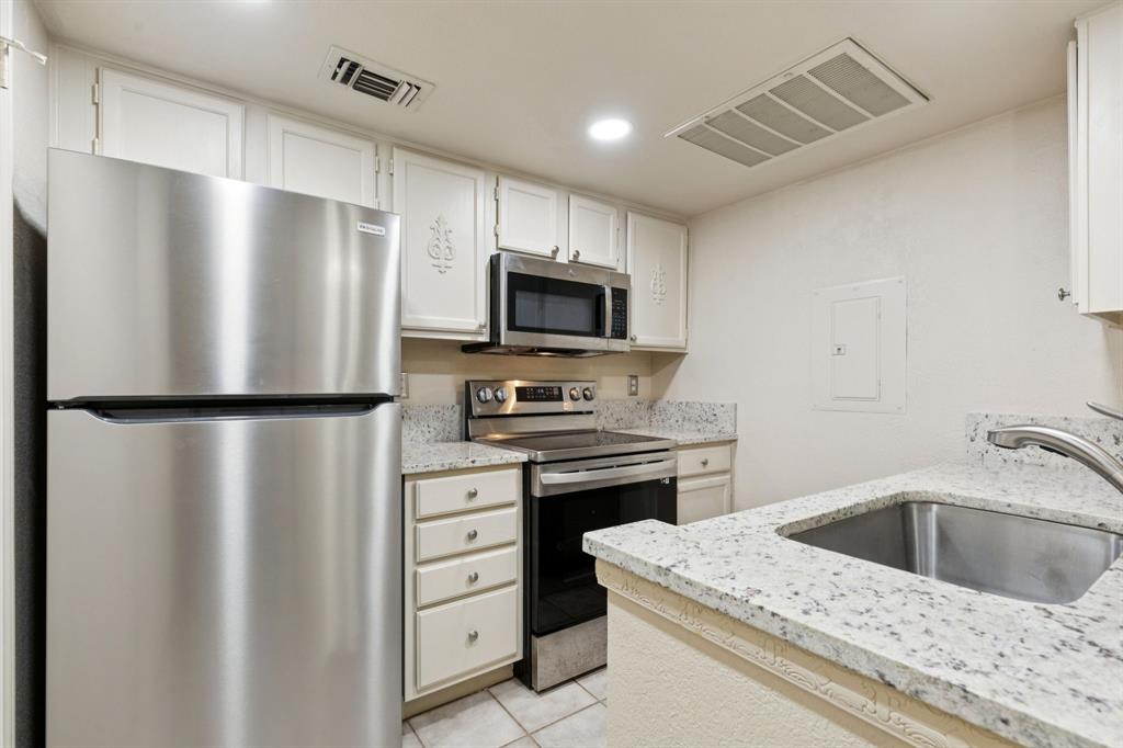 449 Harris Street, Unit 103B Coppell, TX 75019 - Photo 10 of 26 a kitchen with a stove refrigerator and microwave