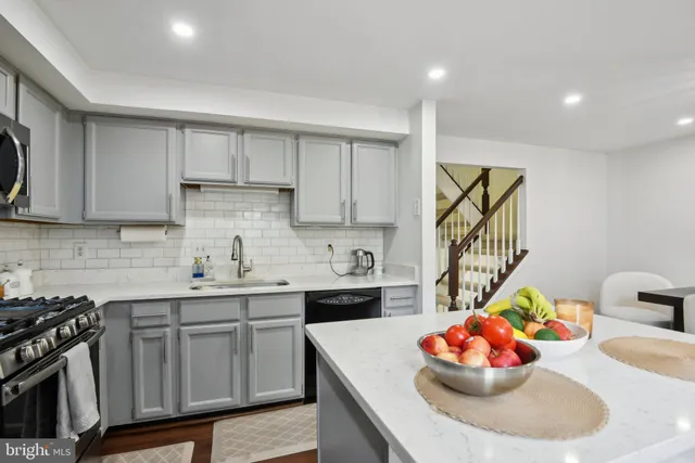 a kitchen with stainless steel appliances a sink a stove a microwave a sink and cabinets