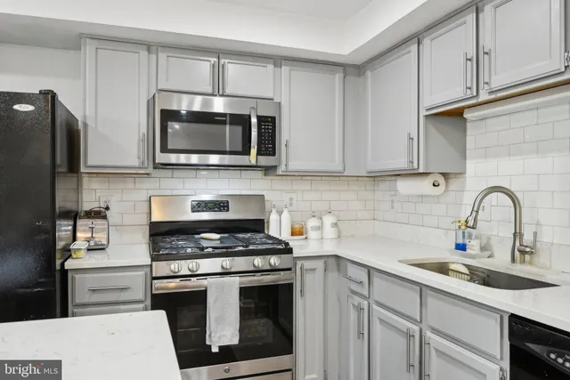 a kitchen with cabinets stainless steel appliances and a sink