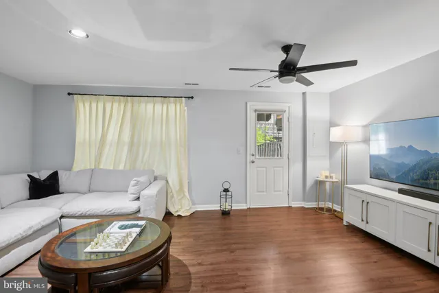 a living room with furniture and a wooden floor