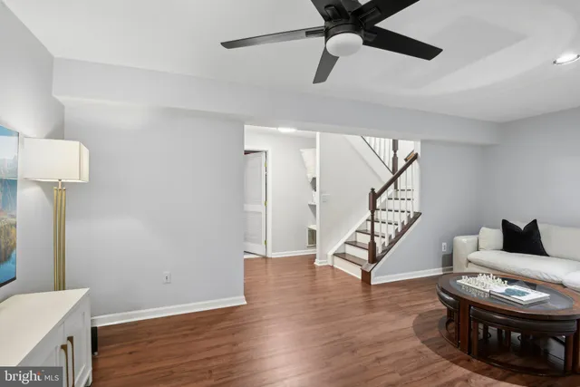 a living room with wooden floor and stairs