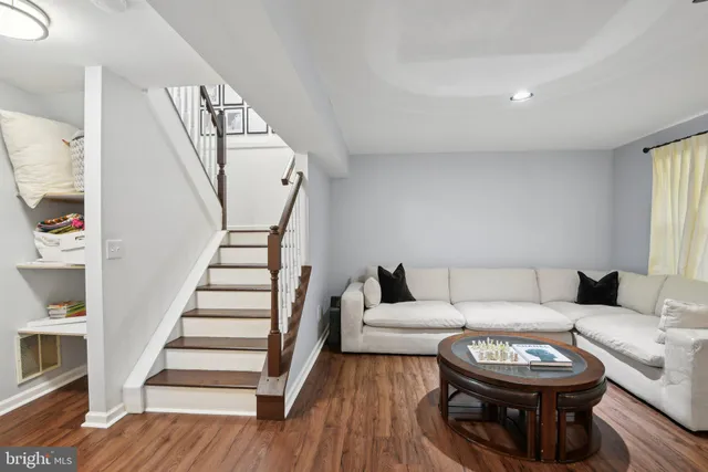 a living room with furniture a rug and white walls