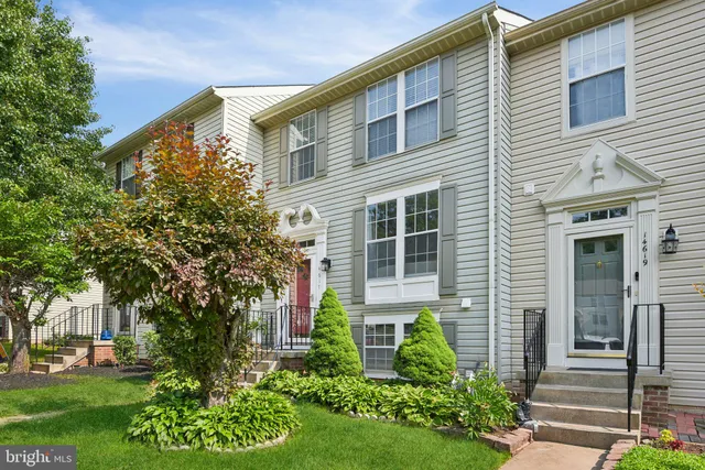 a view of a house with brick walls and a yard with plants