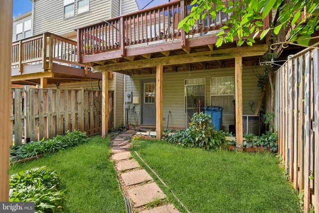 a view of a house with brick walls and a yard with plants