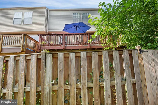 a view of a brick house with wooden fence