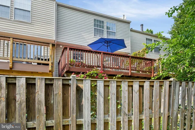 a view of a house with a small yard and wooden fence