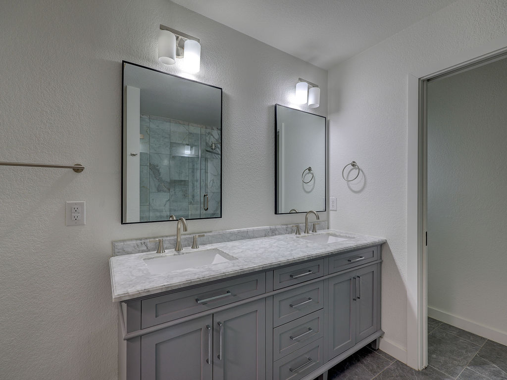 5842 Secrest Drive Austin, TX 78759 - Photo 22 of 40 Double vanities with sleek marble countertops offer ample space for daily routines.