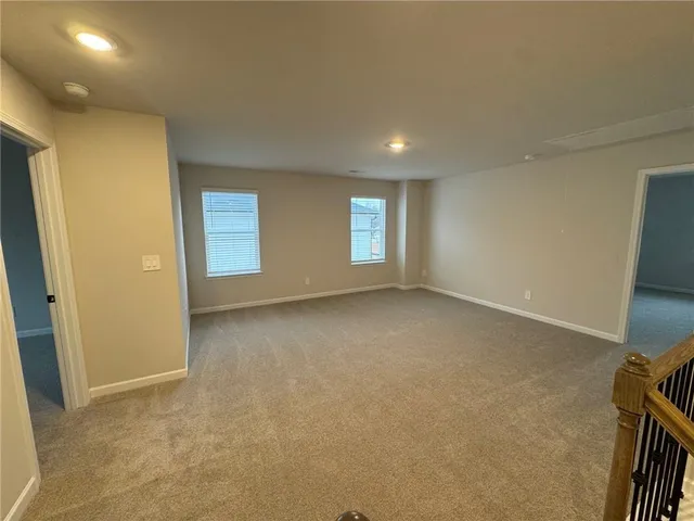 a view of a hallway with wooden floor and stairs