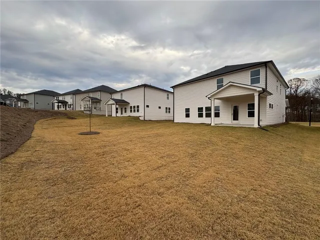a large white house with a large pool next to a road