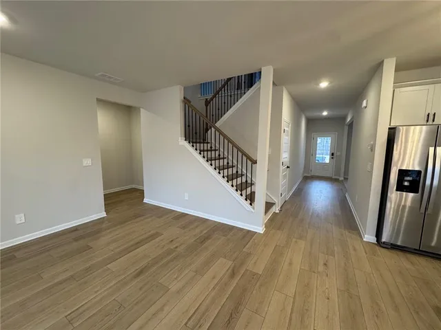 a kitchen that has a lot of stainless steel appliances wooden floor and wooden cabinets