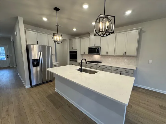 a kitchen with stainless steel appliances a stove microwave and cabinets