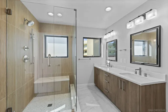a bathroom with a double vanity sink mirror and shower