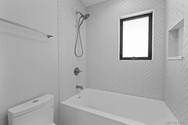 a bathroom with a bath tub a toilet and a shower