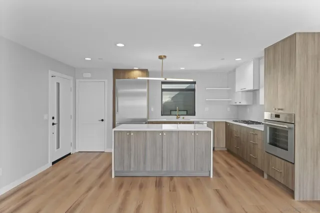 a kitchen with stainless steel appliances granite countertop a stove a sink and a refrigerator