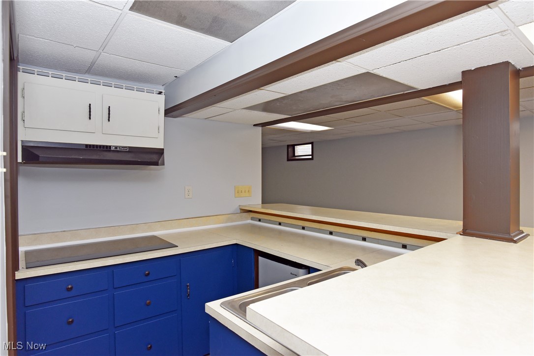 2276 Raber Road, Unit F Uniontown, OH 44685 - Photo 25 of 30 Kitchen featuring a paneled ceiling, light countertops, extractor fan, black electric cooktop, and white cabinets