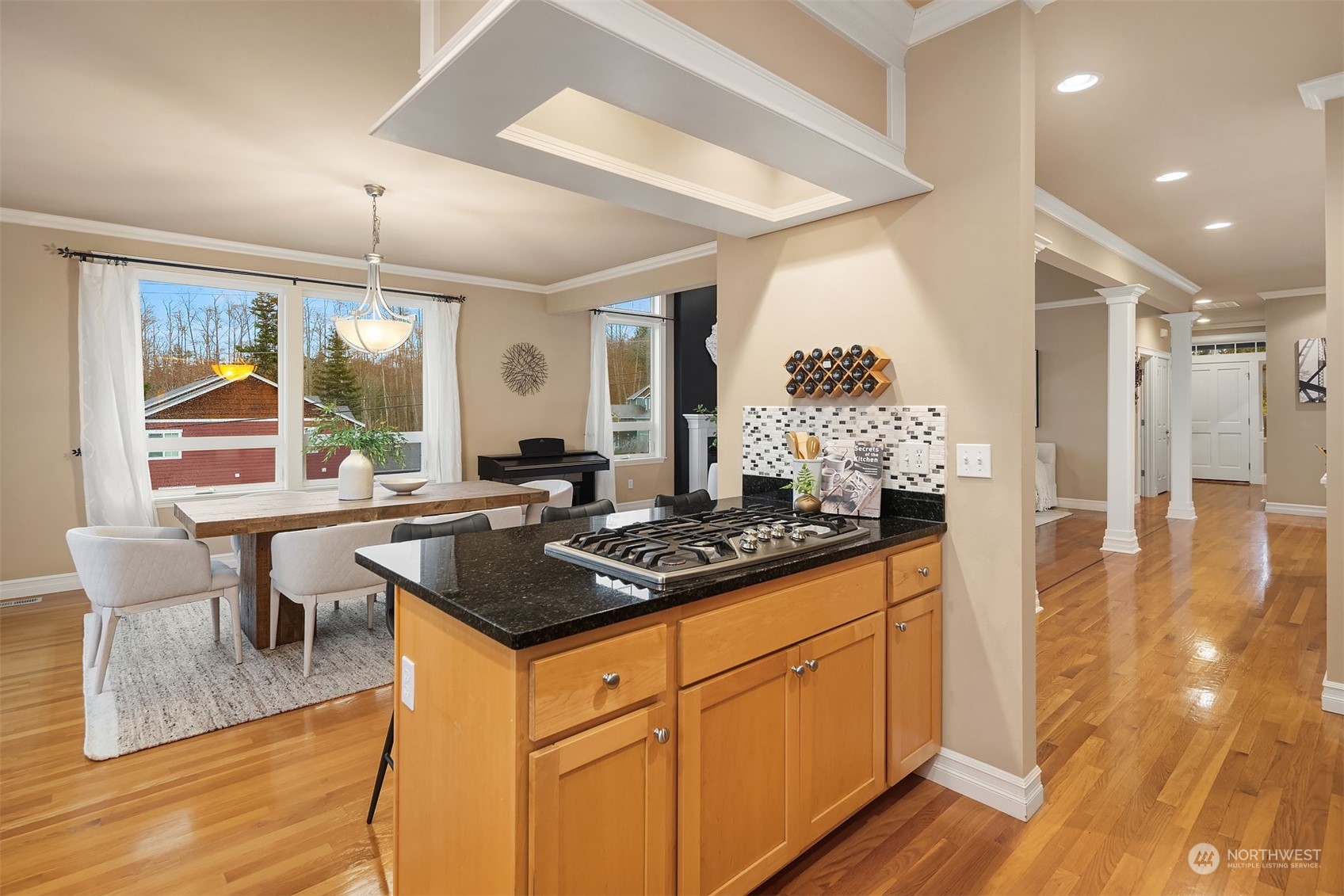 2202 19th Street Anacortes, WA 98221 - Photo 17 of 33 a kitchen with granite countertop a stove a sink dishwasher and a dining table with wooden floor
