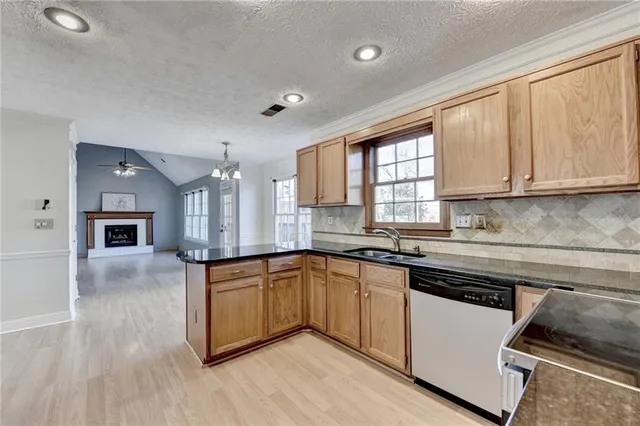a kitchen with stainless steel appliances granite countertop a refrigerator sink and stove