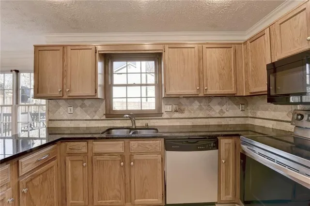 a kitchen with stainless steel appliances granite countertop a refrigerator stove microwave and sink