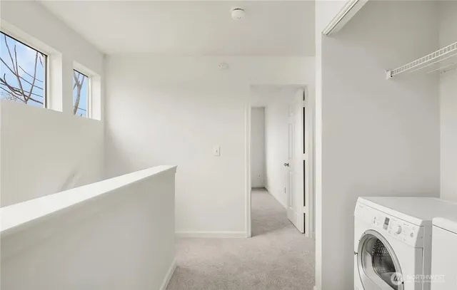 a view of kitchen and empty room with wooden floor