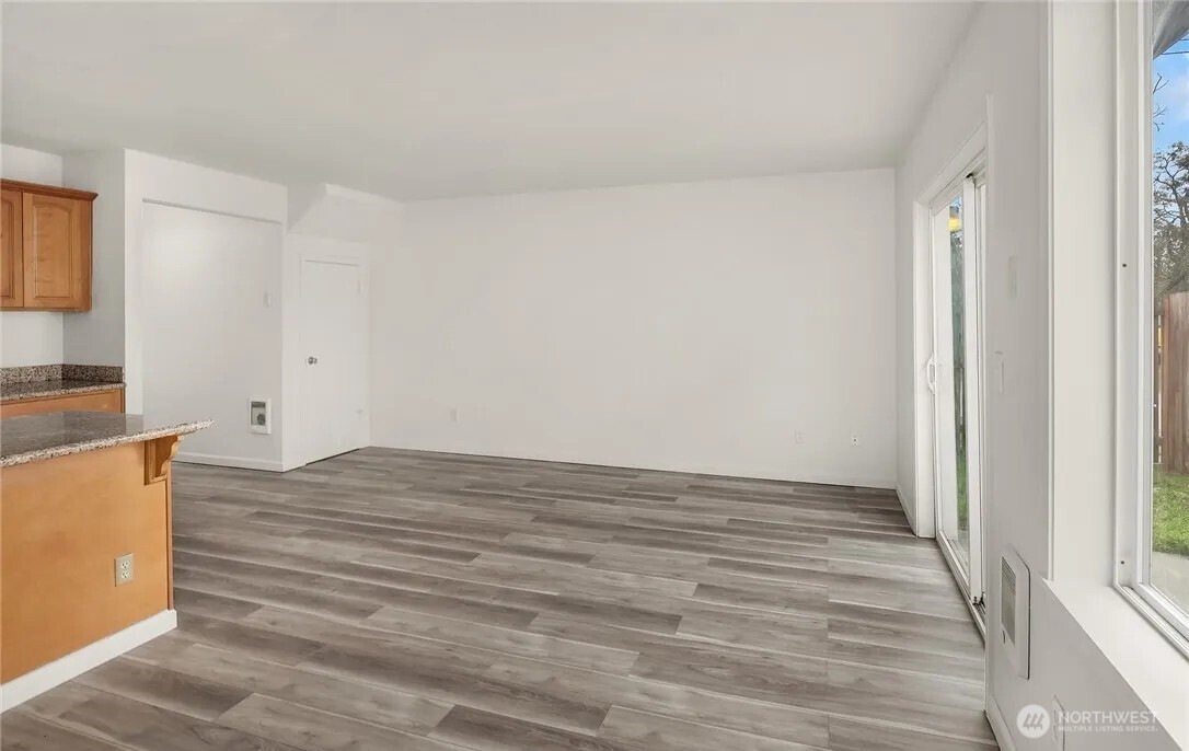 4050 South Puget Sound Avenue Tacoma, WA 98409 - Photo 19 of 19 a view of kitchen and empty room with wooden floor