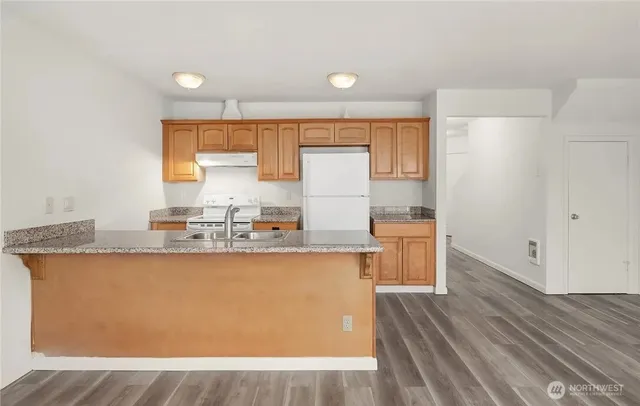 a kitchen with granite countertop a sink window and cabinets
