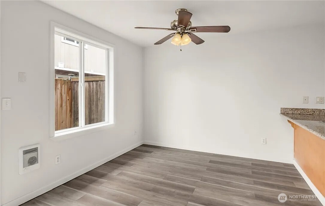 4050 South Puget Sound Avenue Tacoma, WA 98409 - Photo 5 of 19 an empty room with wooden floor fan and windows