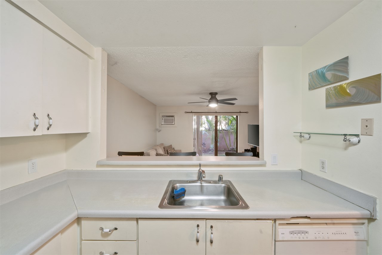 2747 South Kihei Road, Unit C005 Kihei, HI 96753 - Photo 15 of 29 a kitchen with cabinets a sink and dishwasher a stove with wooden floors