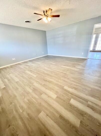 2802 40th Street Lubbock, TX 79413 - Photo 2 of 11 an empty room with a ceiling fan and wooden floor