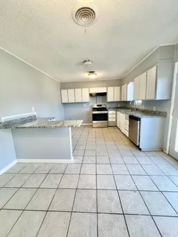 a kitchen with stainless steel appliances granite countertop a sink a stove a microwave and cabinets