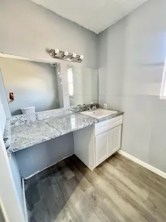 a bathroom with a granite countertop toilet and a sink