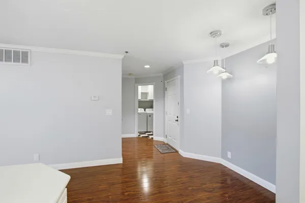 a view of an empty room with wooden floor